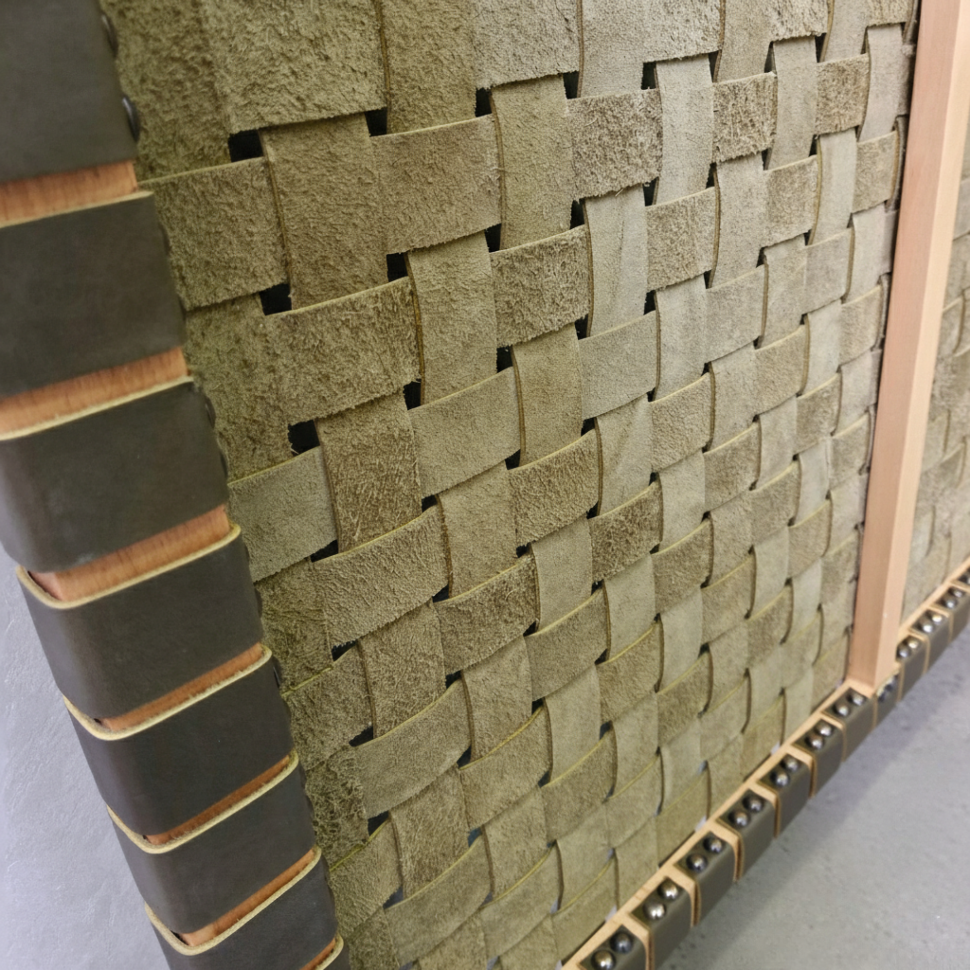 Woven stone-like panel with wooden border on a gray surface