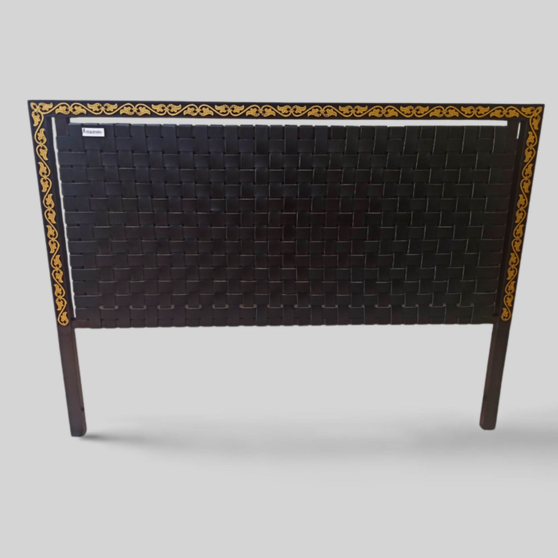 Close-up of handwoven leather strap across solid teak headboard