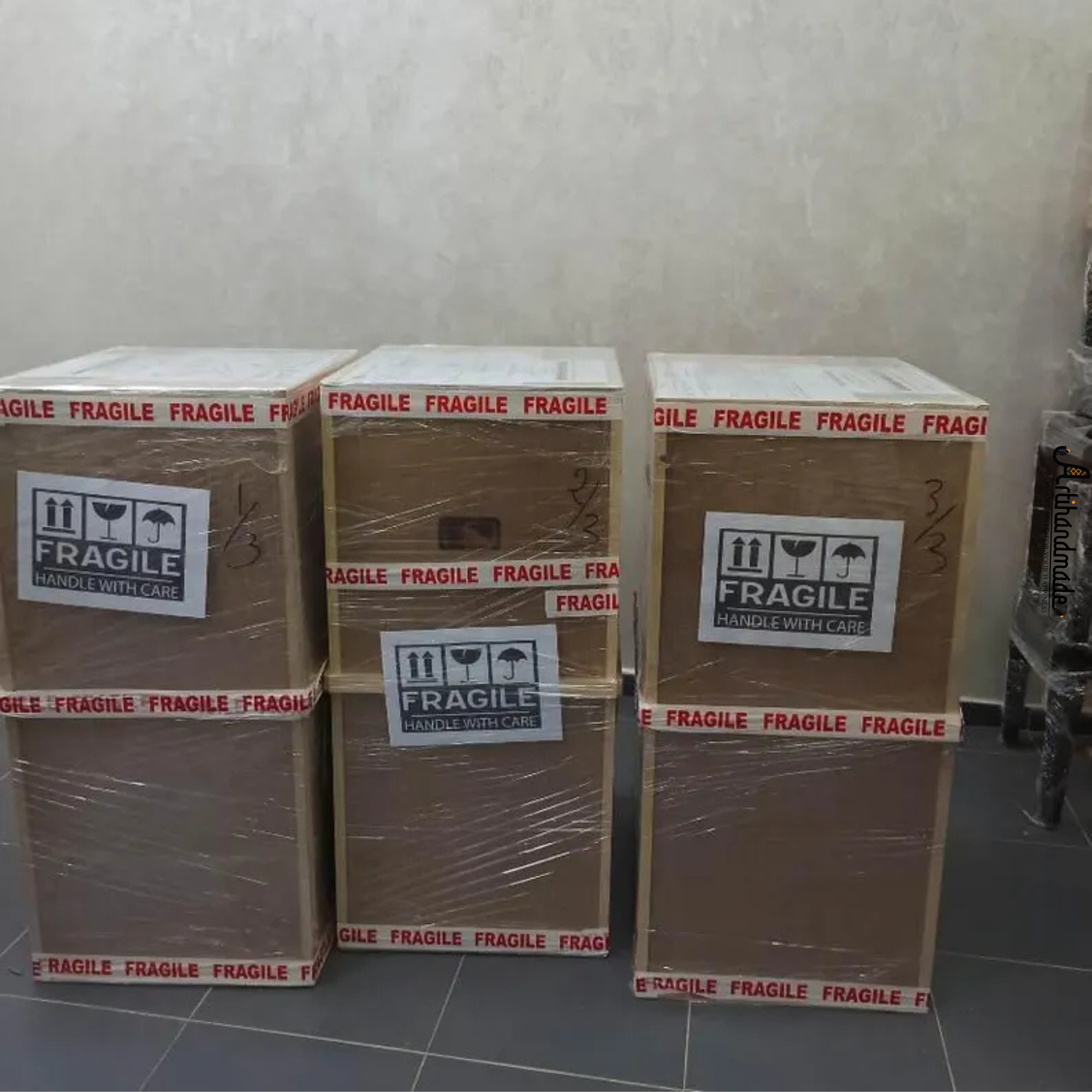 Stack of cardboard boxes with 'Fragile' labels on a tiled floor.