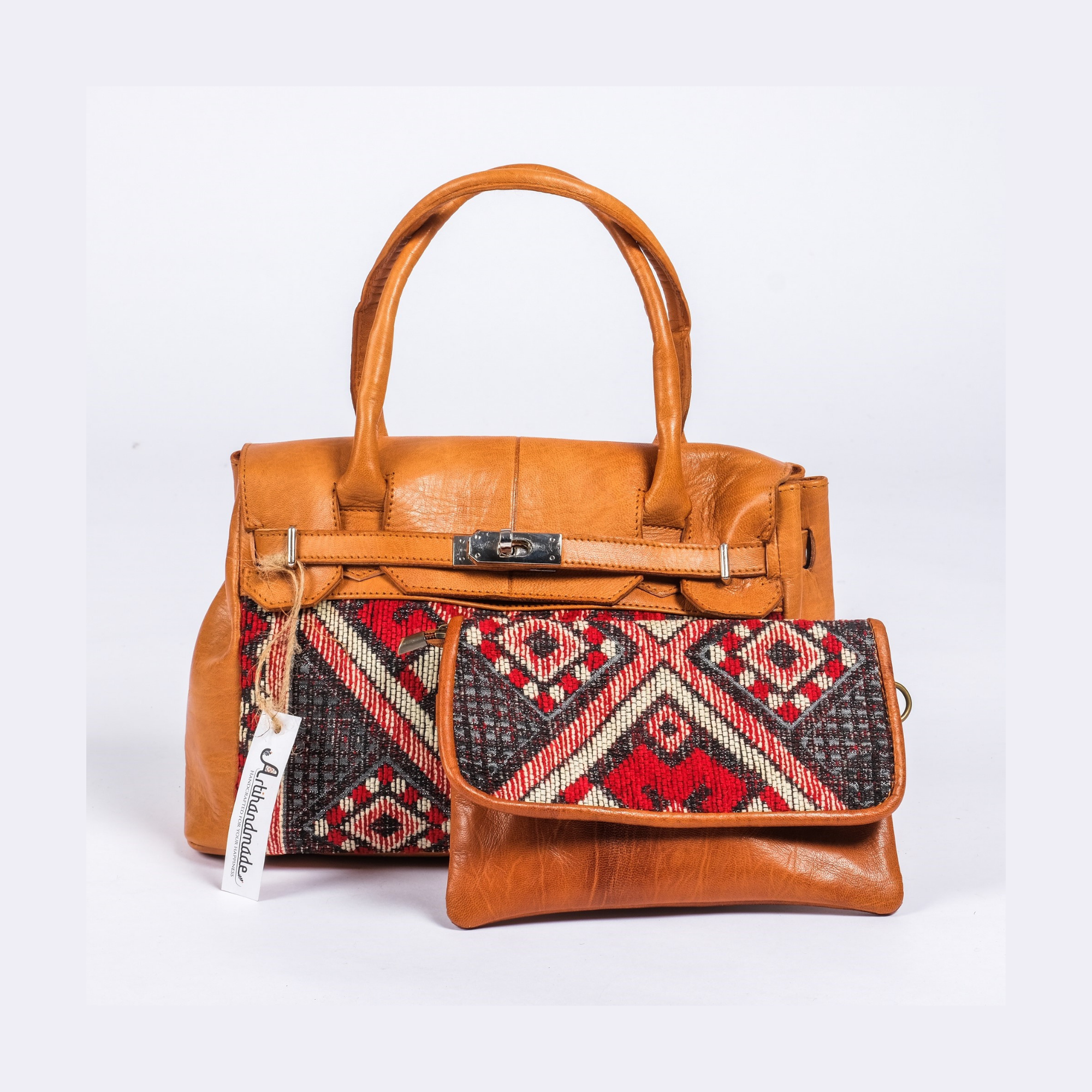 A bohemian style tote bag with a brown leather exterior and a black and red geometric patterned fabric on the sides. It includes a crossbody sling bag.